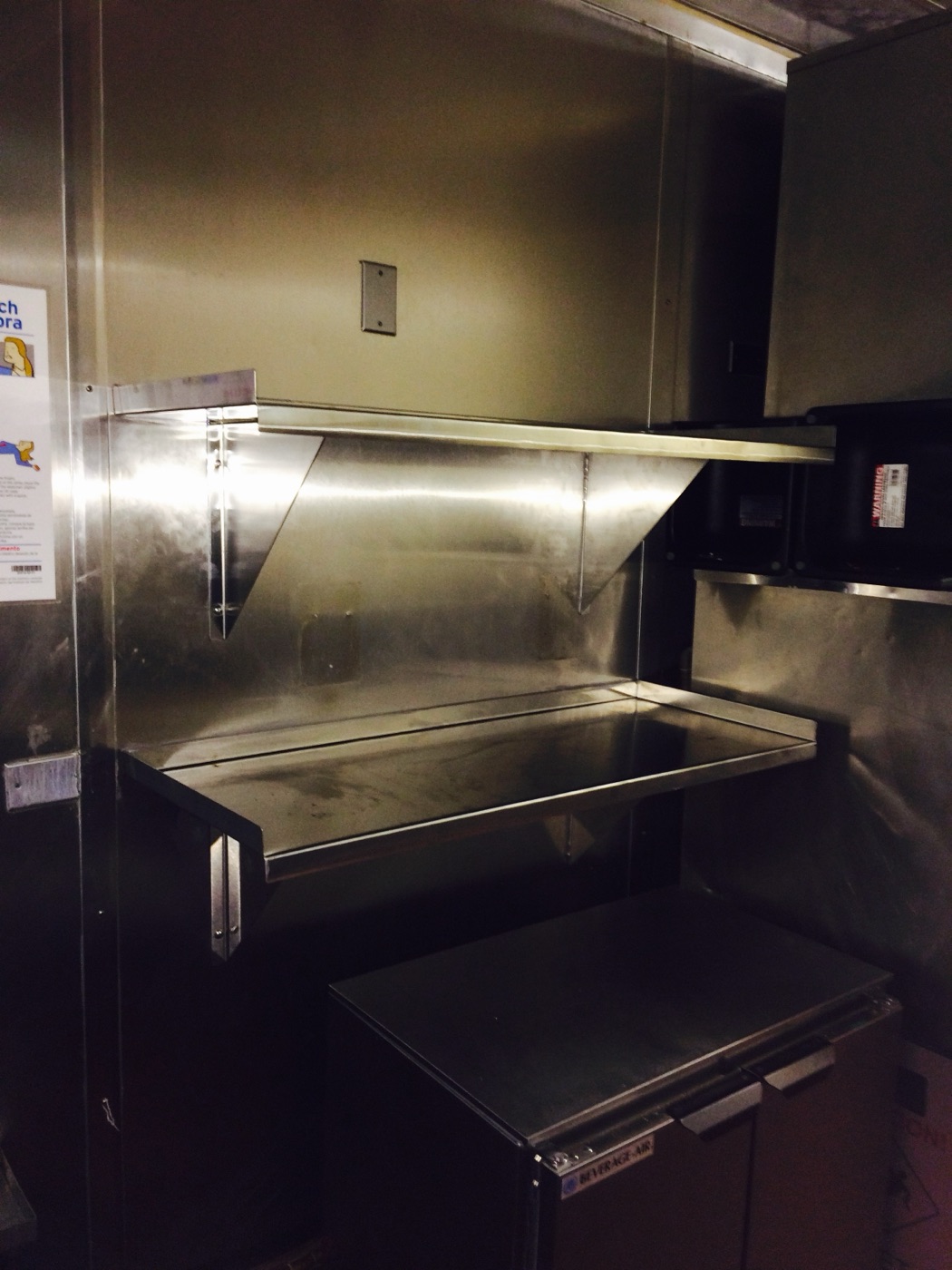 Custom stainless wall shelf and counter in a commercial kitchen