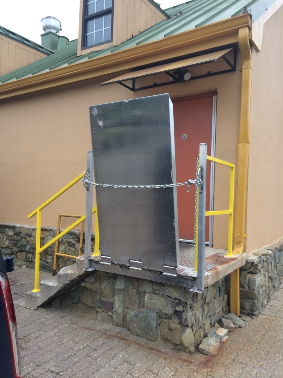 Stainless access lift and platform at a building entrance