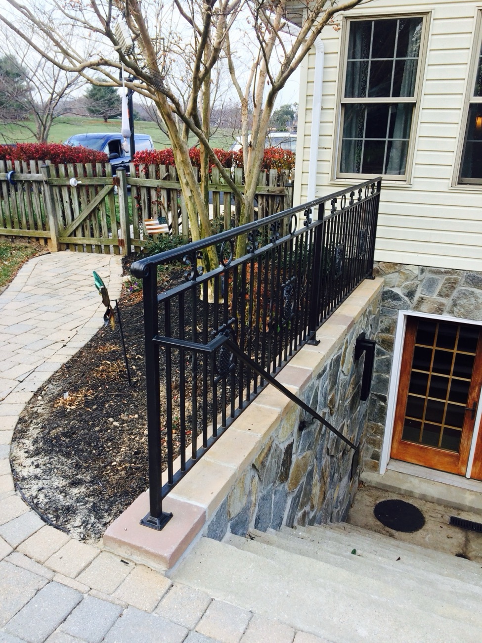 Custom exterior iron stair railing on a stone porch